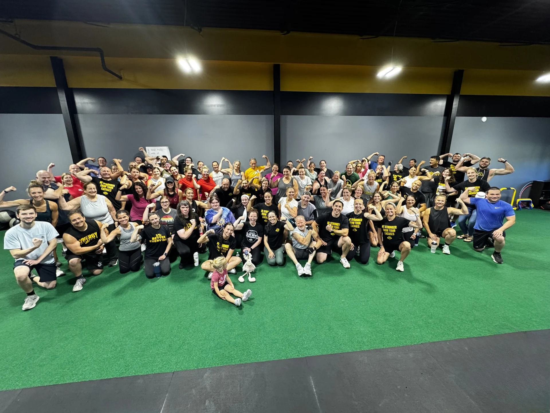Synergy Athletics members together on the gym turf